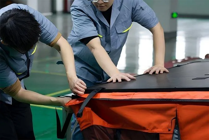 Workers performing final assembly of Hard Shell roof tents. Strict Quality Control before packaging for export.