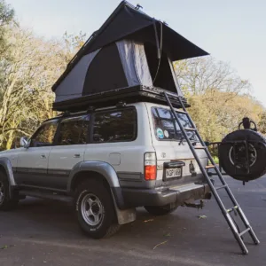 Luxury aluminum clamshell roof top tent mounted on SUV, featuring 360-degree panoramic view and aerodynamic design, manufactured by Camp Auto Parts.